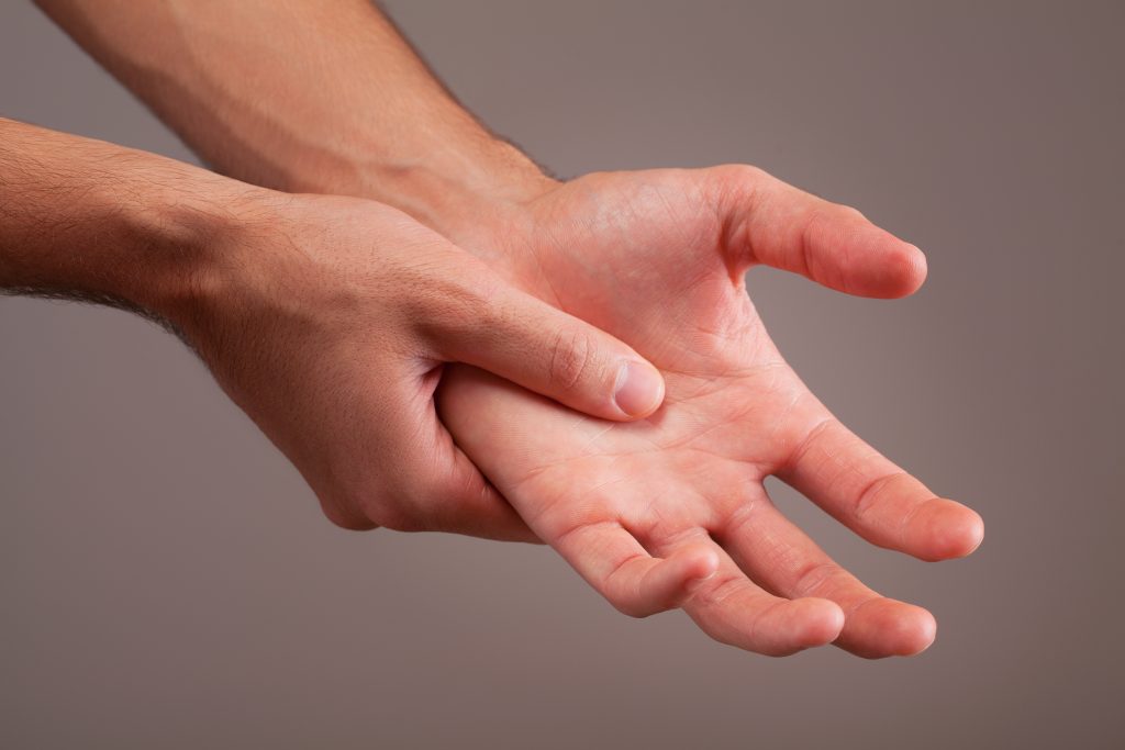 Nahaufnahme eines Händedrucks bei einer medizinischen Behandlung.